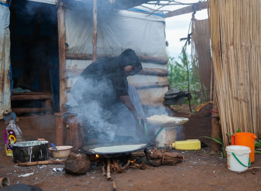 تواجه ميادة وغيرها من النساء اللاتي يستخدمن الحطب للطهي،
بسبب انعدام غاز الطهي في المعسكر وارتفاع أسعار الفحم، مخاطر
صحية عديدة، منها أمراض الجهاز التنفسي، وأمراض العيون،
والتسمم بأول أكسيد الكربون.
إعداد وعواسة الكسرة بواسطة الحطب لتحضير وجبة الغداء.
5 اقتصادات اللجوء والهجرة
